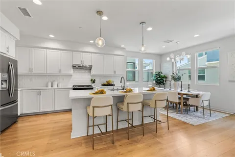 a large white kitchen with lots of counter space furniture and appliances