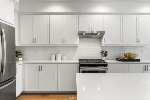 a kitchen with granite countertop white cabinets and stainless steel appliances