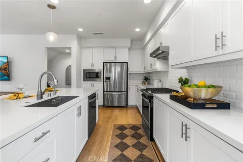 a kitchen with a sink stainless steel appliances and cabinets