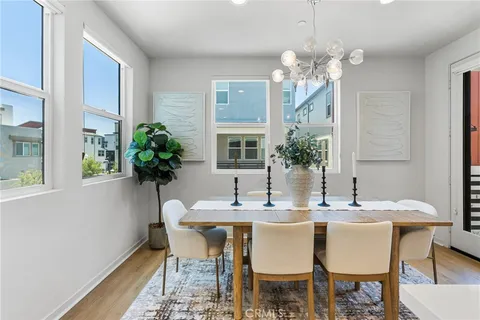 a dining room with furniture potted plants and wooden floor