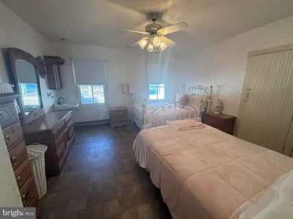 a bedroom with a bed dresser and a window