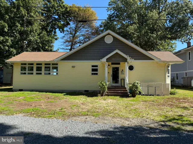 a kitchen with stainless steel appliances kitchen island granite countertop a stove a refrigerator a sink and dishwasher with wooden floor