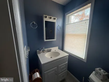a view of a livingroom with furniture hardwood floor a ceiling fan and a window