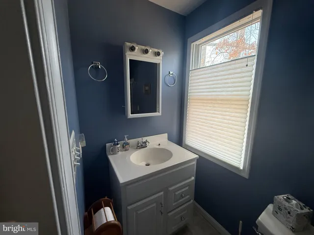 a view of a livingroom with furniture hardwood floor a ceiling fan and a window