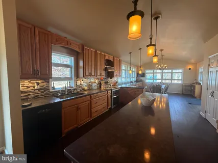 a kitchen with lots of counter space dining table and stainless steel appliances