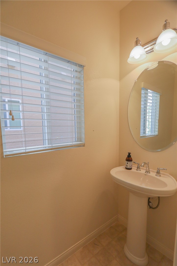 6418 Jackson Spring Road Las Vegas, NV 89118 - Photo 4 of 20 A well-appointed powder room features a classic pedestal sink and bright window.