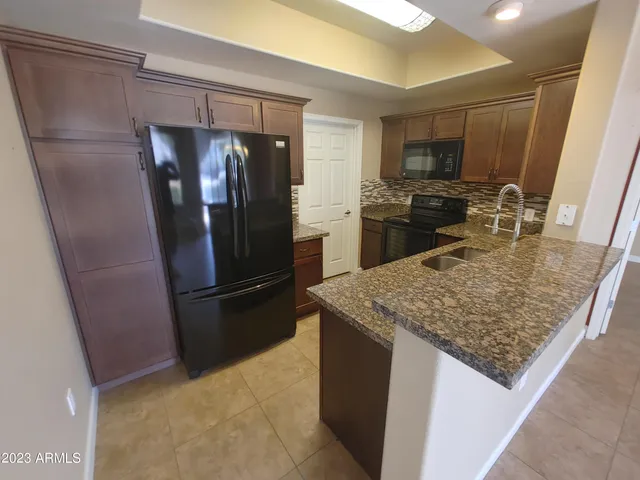 a kitchen with granite countertop a sink and a stove