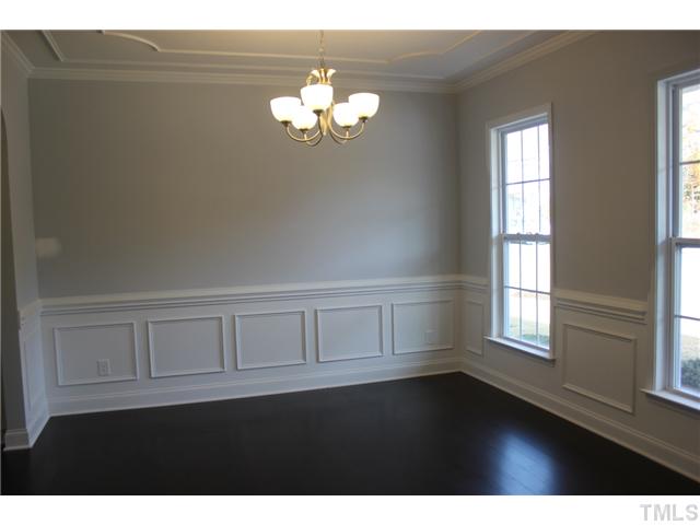 6920 Rex Road Holly Springs, NC 27540 - Photo 3 of 24 Formal Dining Room features 5 inch wide plank floors, chair rail, wainscot, crown & ceiling ornamentation. A great space for Holidays!
