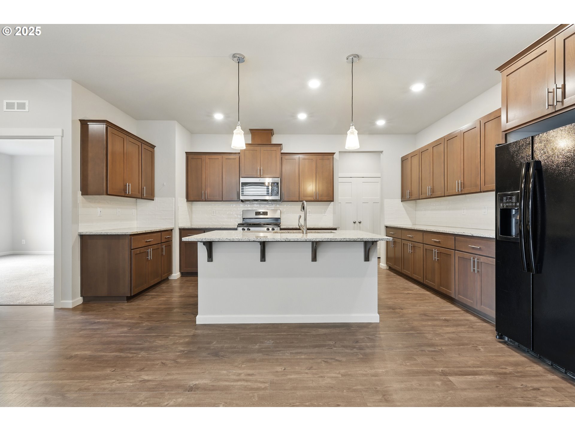 2582 Southwest Thomas Way Gresham, OR 97080 - Photo 14 of 36 a large kitchen with kitchen island a sink a center island stainless steel appliances and a counter top space