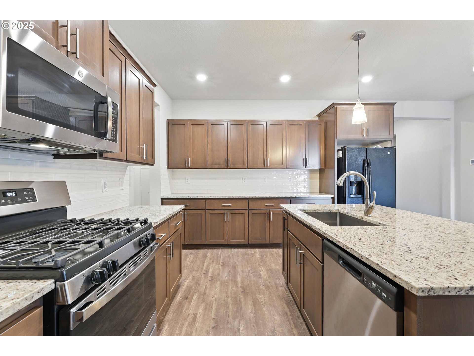 2582 Southwest Thomas Way Gresham, OR 97080 - Photo 17 of 36 a kitchen with kitchen island granite countertop a stove and a sink