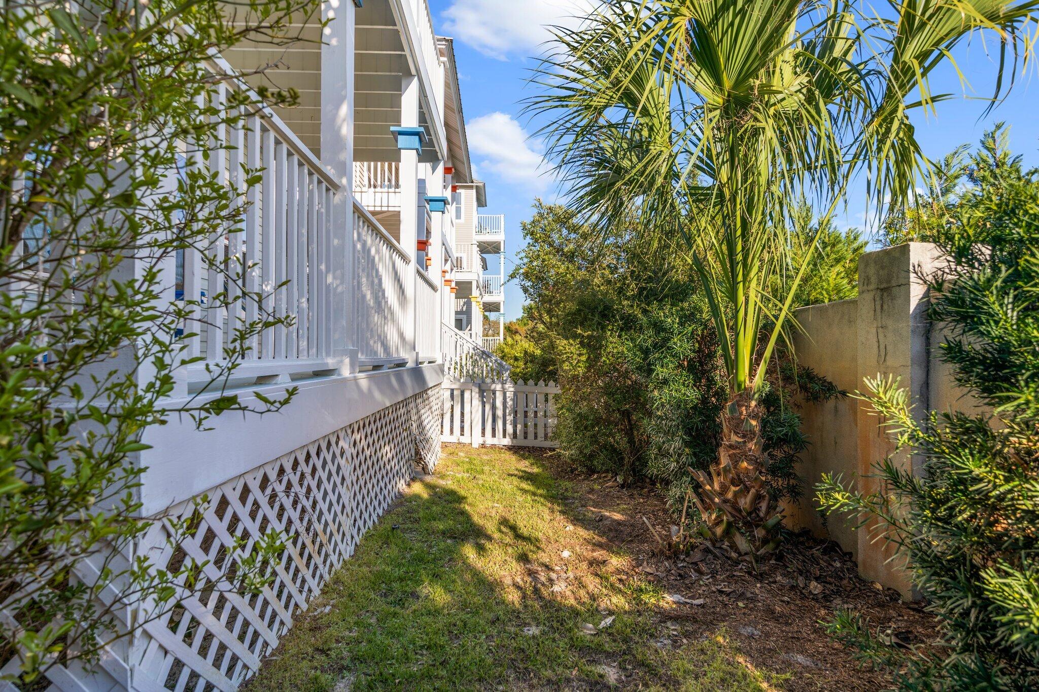 156 Emerald Dunes Circle Santa Rosa Beach, FL 32459 - Photo 30 of 43 a view of a yard with plants and wooden fence