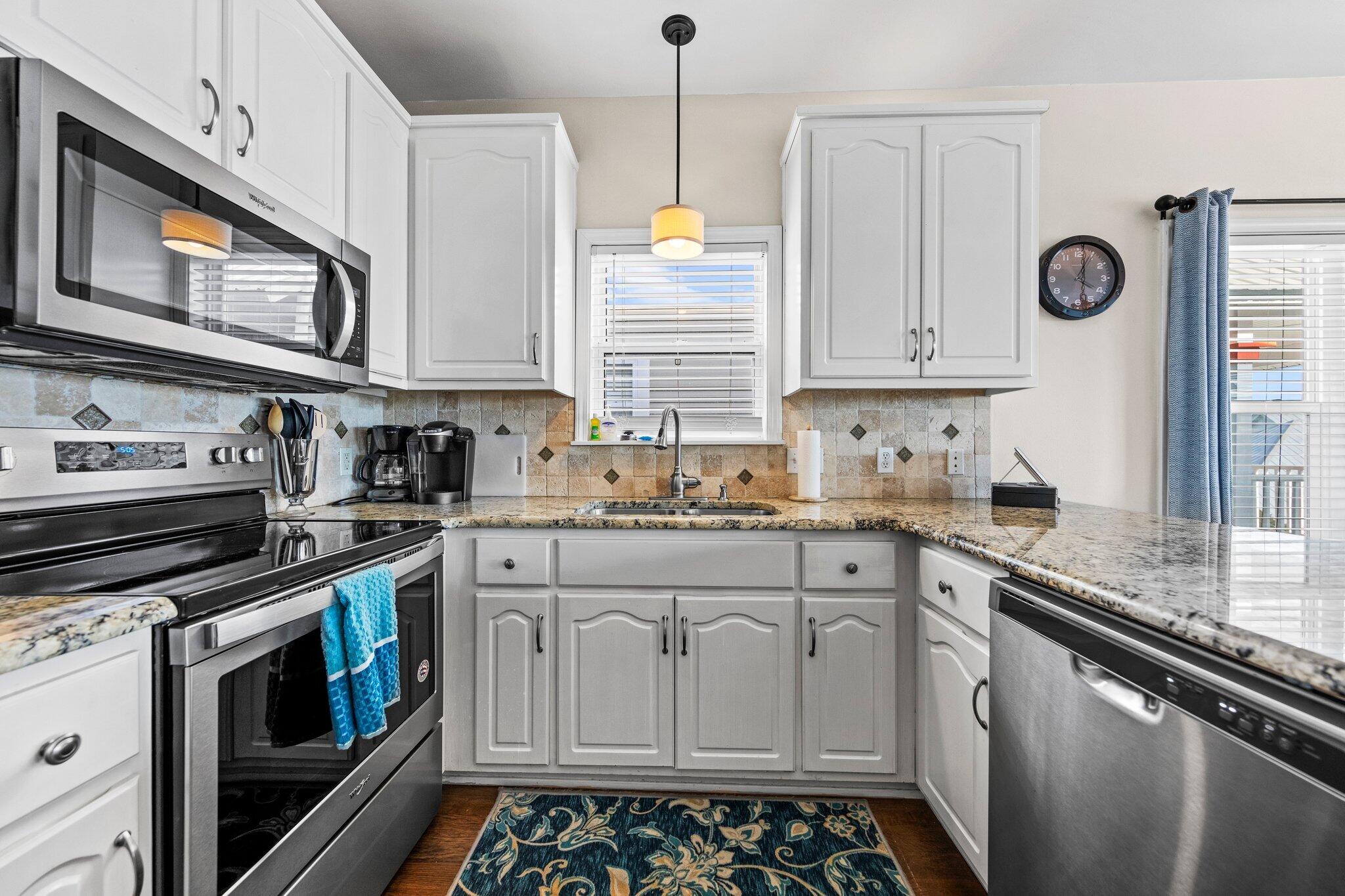156 Emerald Dunes Circle Santa Rosa Beach, FL 32459 - Photo 8 of 43 a kitchen with stainless steel appliances a stove a sink and a microwave