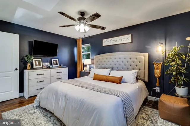 a bedroom with a bed a flat screen tv and a chandelier