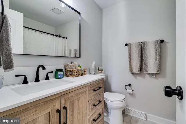a bathroom with a sink a toilet and mirror