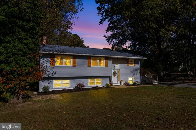 a front view of a house with a yard and tree s