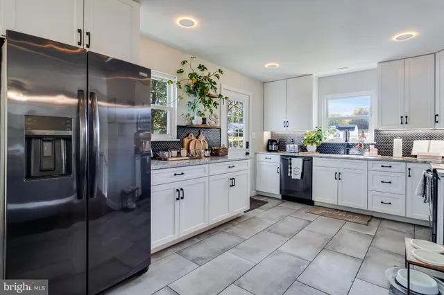 a kitchen with stainless steel appliances a refrigerator sink and cabinets