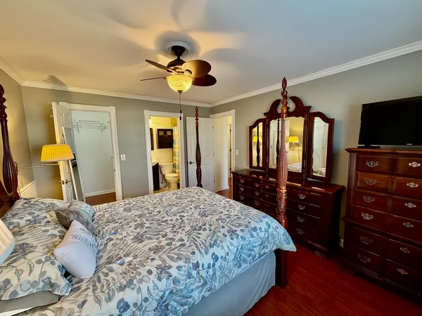 a bedroom with a bed and a flat tv screen on dresser
