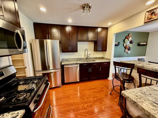 a kitchen with stainless steel appliances granite countertop a stove a sink and a refrigerator