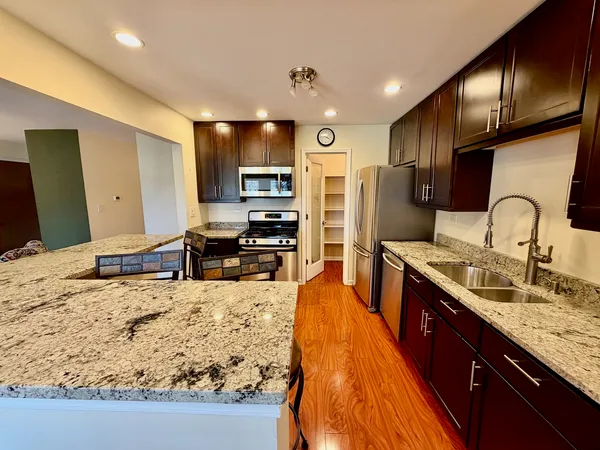 a large kitchen with kitchen island granite countertop a sink and counter space