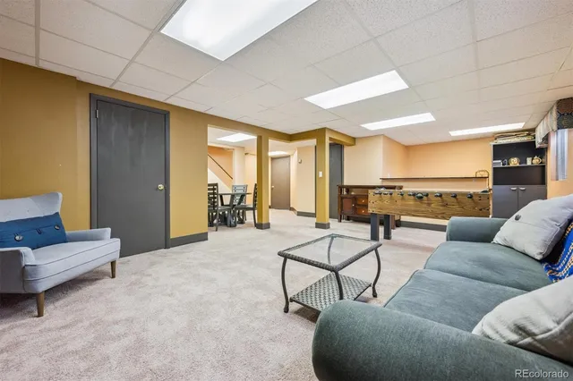 a living room with furniture and a view of kitchen