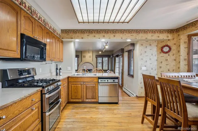 a kitchen with stainless steel appliances granite countertop a stove a sink and a microwave