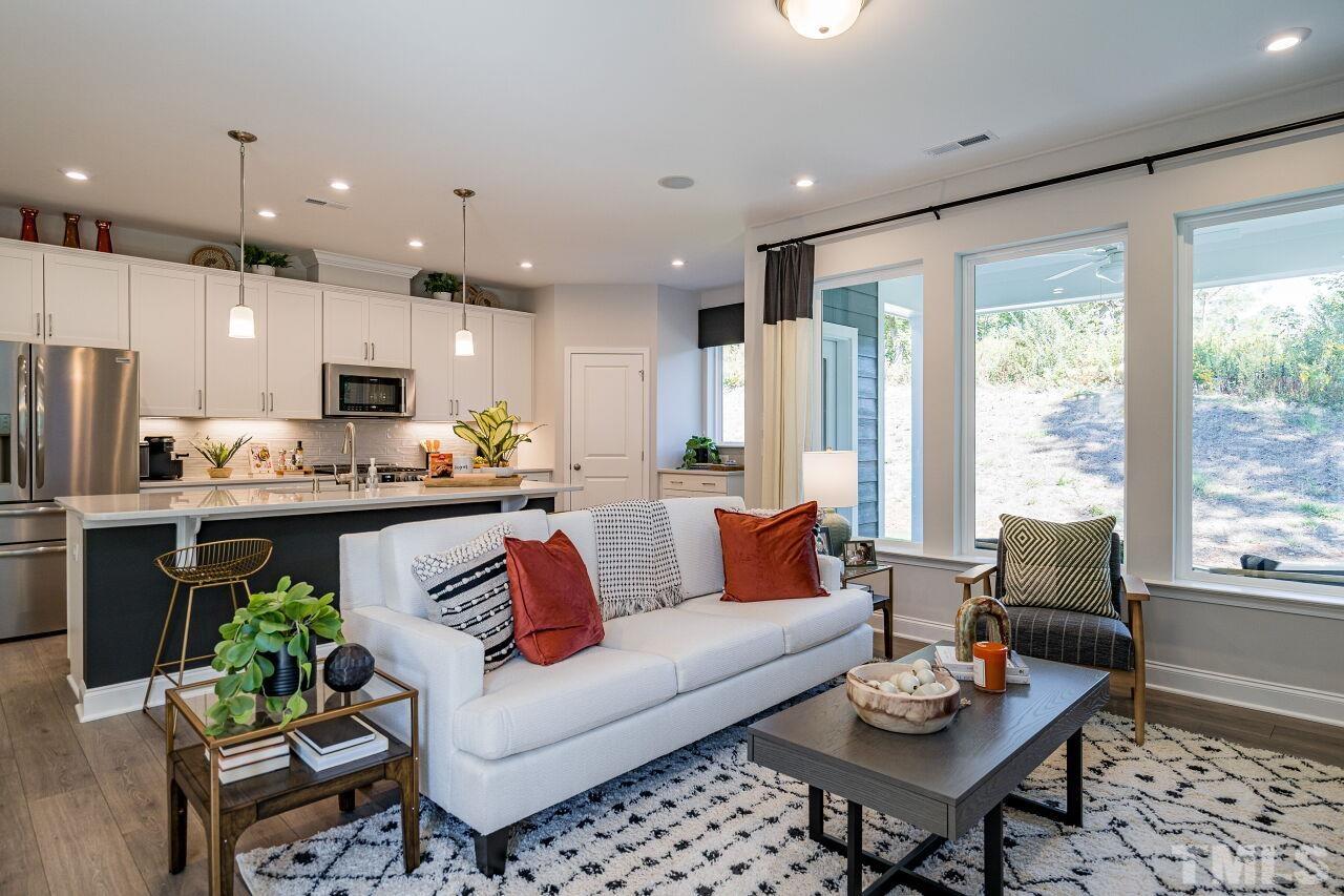 a living room with furniture kitchen and a large window