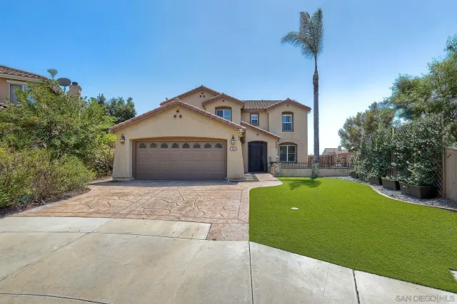 a front view of a house with a garden and yard