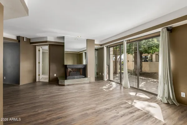 a view of an empty room with glass door and a window
