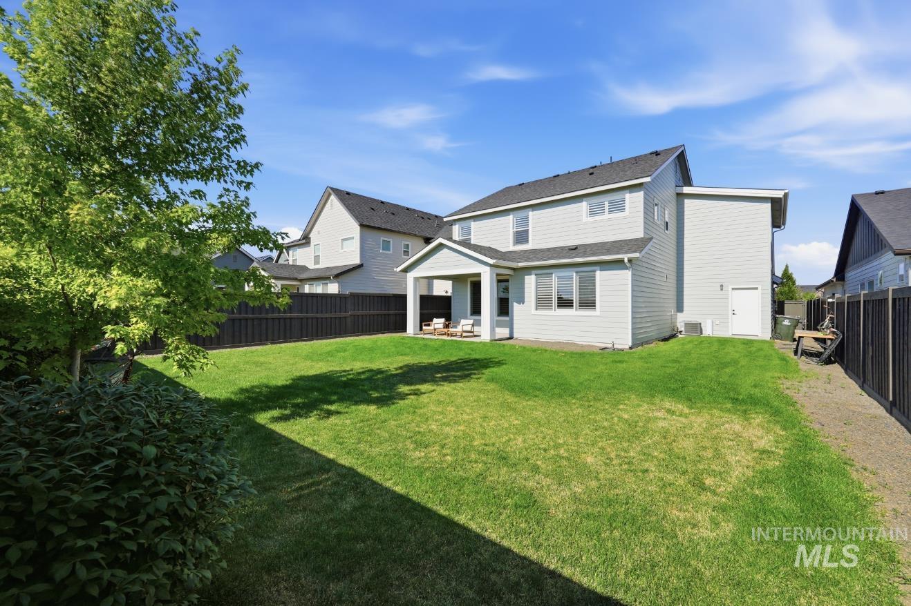 6933 South Zenith Avenue Meridian, ID 83642 - Photo 31 of 34 Expansive backyard featuring a lush lawn, privacy fencing, and mature landscaping