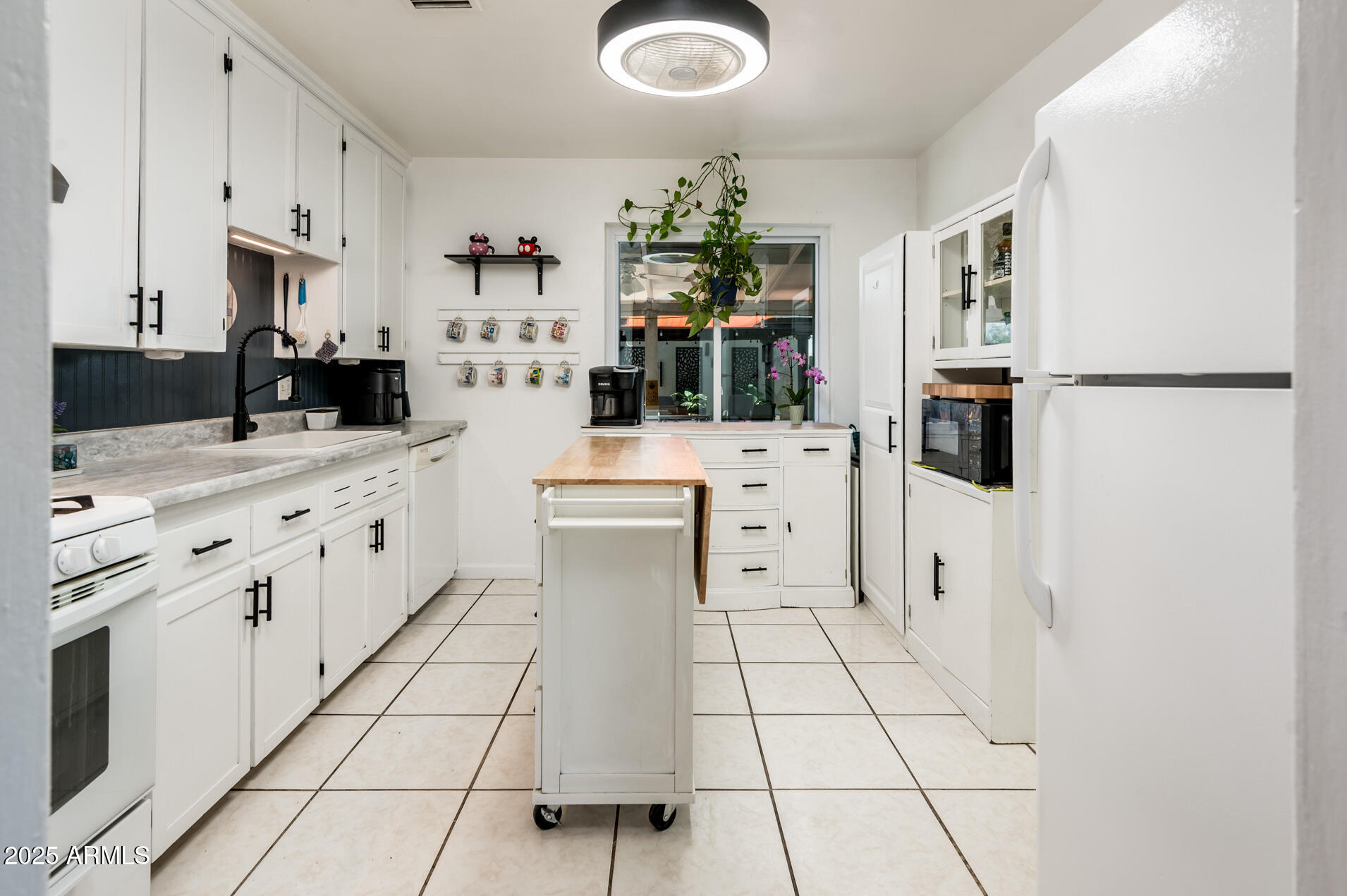 2221 West Mitchell Drive Phoenix, AZ 85015 - Photo 18 of 45 a kitchen with white cabinets and appliances