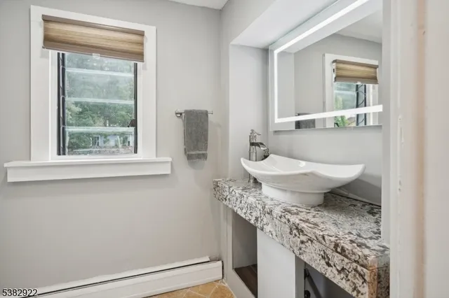 a bathroom with a granite countertop sink and a mirror
