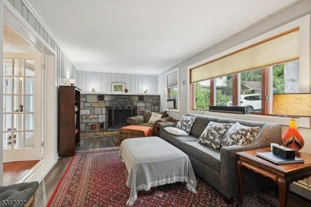 a living room with furniture fireplace and a large window