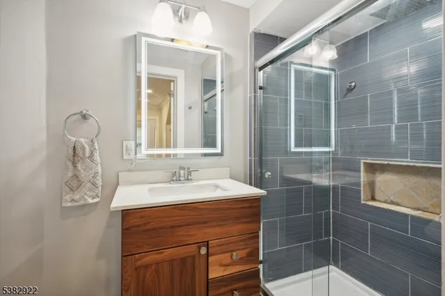 a bathroom with a sink mirror and shower
