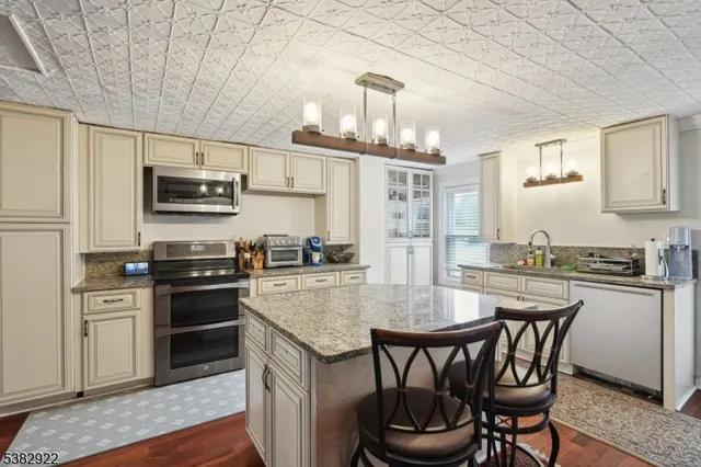 a kitchen with granite countertop a table chairs microwave and cabinets