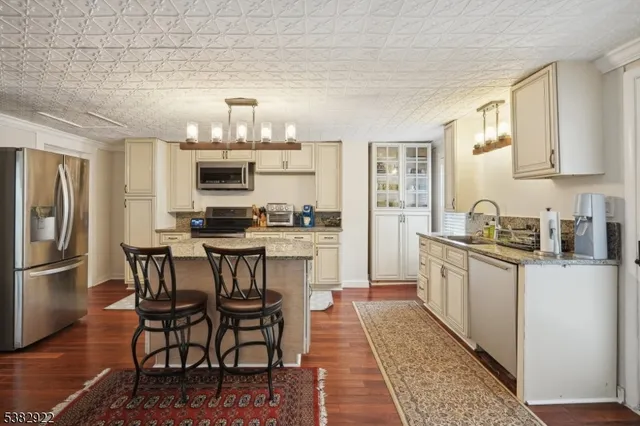 a kitchen with a dining table chairs and refrigerator