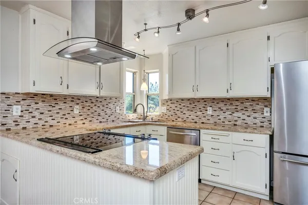 a kitchen with granite countertop a sink stainless steel appliances and cabinets