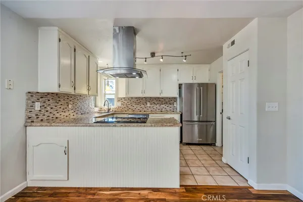 a kitchen with stainless steel appliances granite countertop a refrigerator and a stove