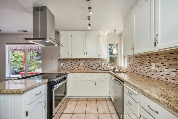 a kitchen with granite countertop a sink stove and cabinets