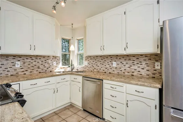 a kitchen with granite countertop white cabinets and white appliances