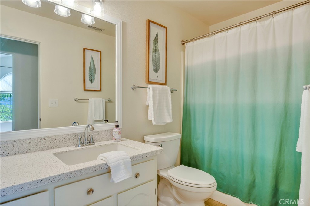 15632 Little Peak Road Hidden Valley Lake, CA 95467 - Photo 24 of 42 a bathroom with a granite countertop sink a toilet and a mirror