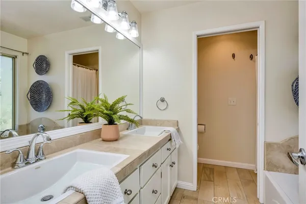 a spacious bathroom with a tub sink and mirror