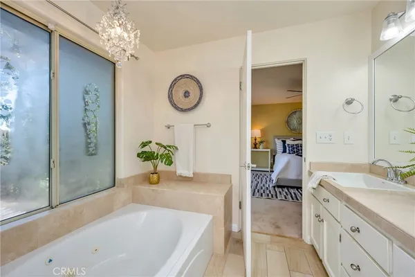 a bathroom with a granite countertop sink a large mirror and a potted plant