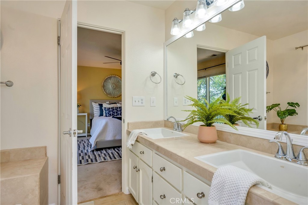 15632 Little Peak Road Hidden Valley Lake, CA 95467 - Photo 31 of 42 a bathroom with a granite countertop sink a large mirror and a potted plant