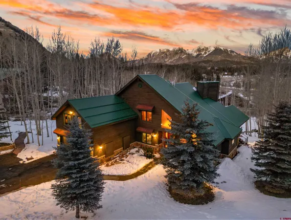 a view of a wooden house with a yard and a fire pit