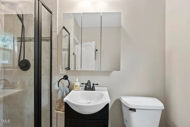 a bathroom with a sink a toilet and shower