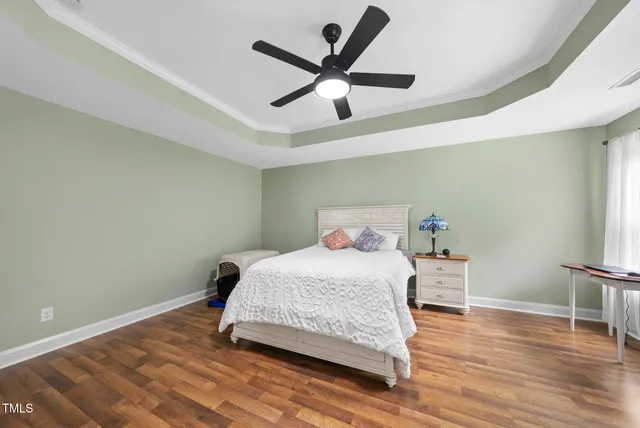 a bedroom with a bed and wooden floor