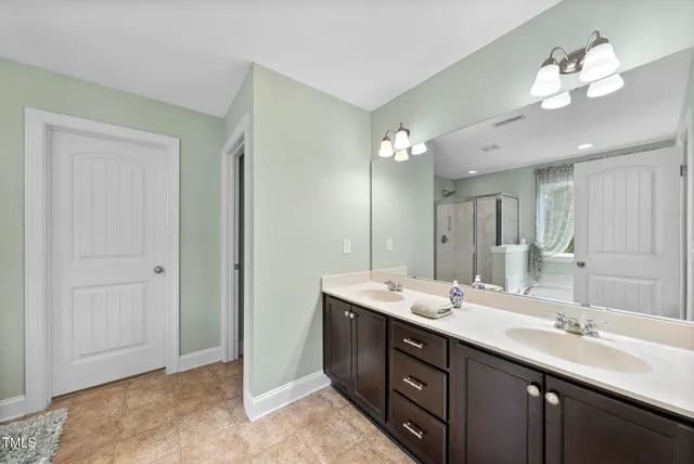 a bathroom with a double vanity sink and a mirror