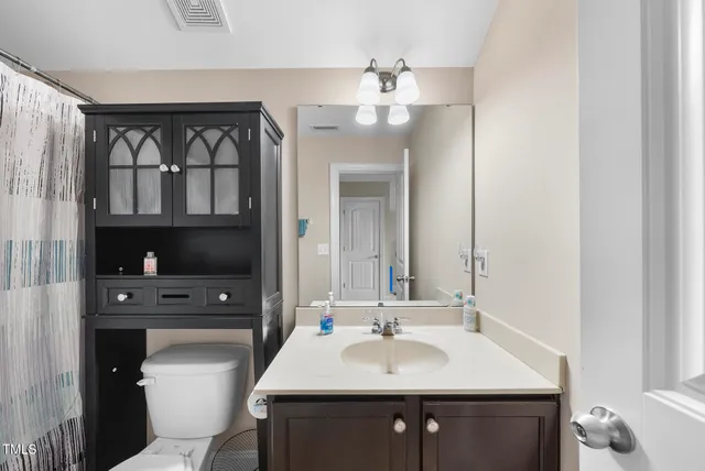 a bathroom with a sink a toilet and a mirror