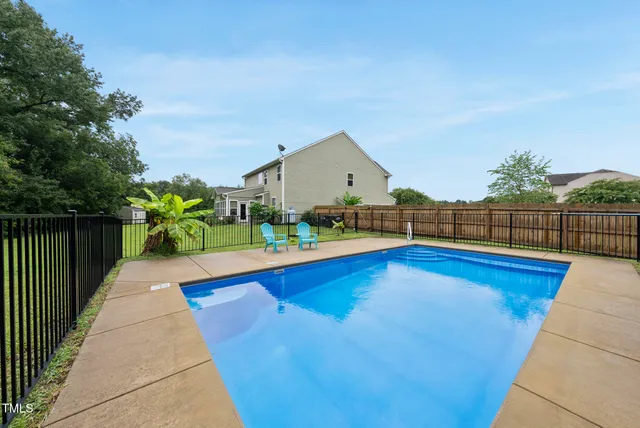 a view of swimming pool with deck and yard