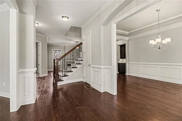 a view of a hallway with wooden floor and staircase